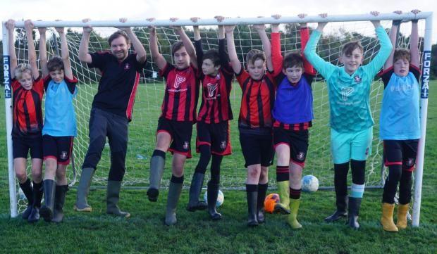 Children in a football goal in wellies