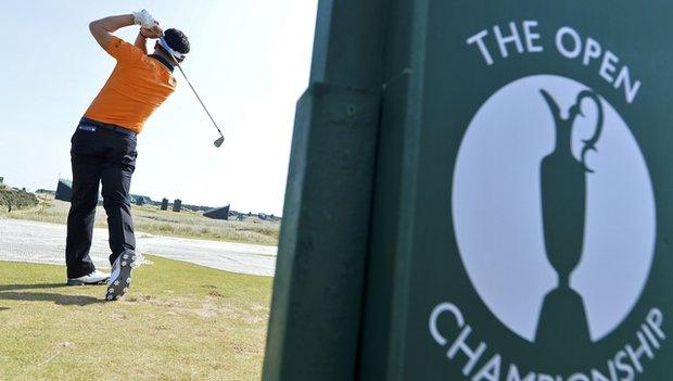 Golfer in front of open championship sign