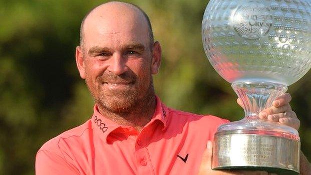 Thomas Bjorn holds the Nedbank Challenge trophy aloft