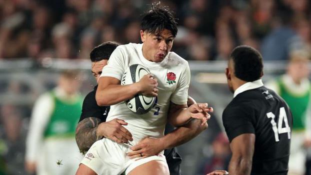 Marcus Smith is tackled during England's narrow defeat by New Zealand at Eden Park in July