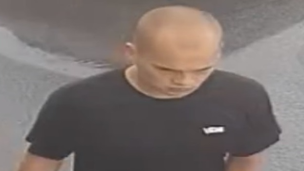 CCTV image released by police of a man with a shaved head and black T'shirt in a street