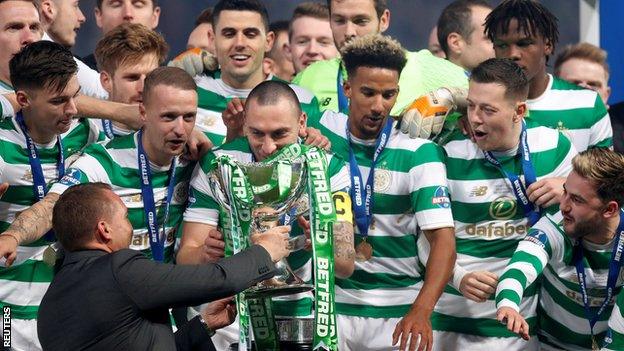 Celtic manager Brendan Rodgers hands the League Cup to captain Scott Brown