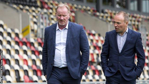 Stuart Davies and Dragons chairman David Buttress walk in front of an empty stand at Rodney Parade