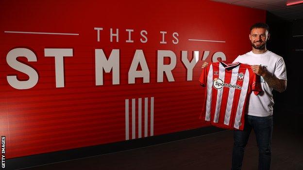 Adam Armstrong posing with a Southampton shirt