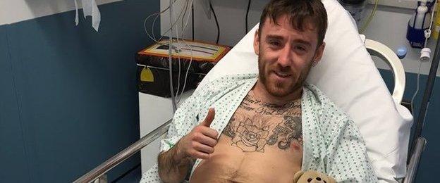 Lee Johnston gives the thumbs up as he is treated in hospital following Sunday's crash