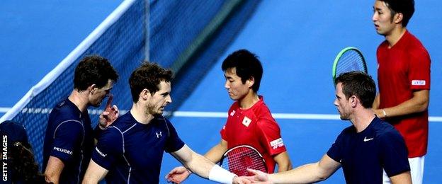 Jamie Murray (L) and Andy Murray (R) of Great Britain clelebrate with their team captain Leon Smith after winning the second set of the doubles match against Yasutaka Uchiyama and Yoshihito Nishioka