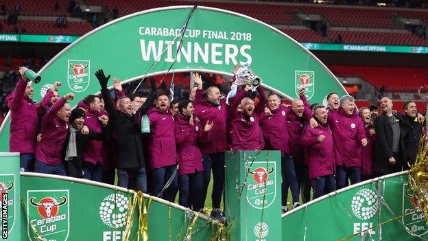 Pep Guardiola manager / head coach of Manchester City celebrates with his coaching staff after winning the Carabao Cup after the Carabao Cup Final match between Arsenal and Manchester City at Wembley Stadium