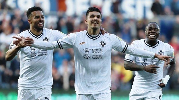 Joel Piroe of Swansea City (C) celebrates his second goal against Bournemouth with Cyrus Christie (L) and Michael Obafemi (R)