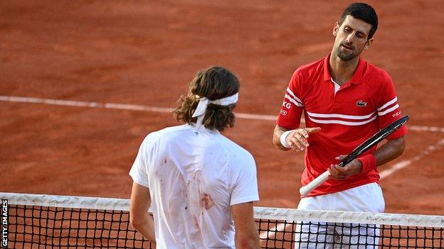 Djokovic shakes hands with Tsitsipas at the net