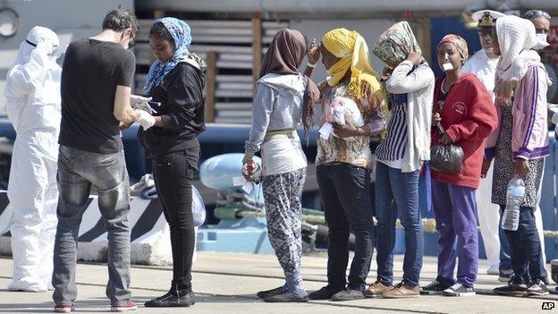 Migrants who set off from the Libyan shores disembark at Messina Harbour in Sicily