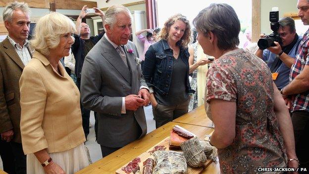 Prince Charles and Duchess of Cornwall being shown local produce