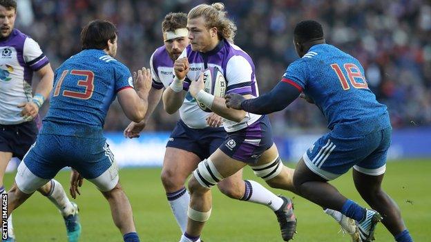 David Denton runs with the ball for Scotland as France duo Remi Lamerat and Cedate Gomes Sa try to tackle him