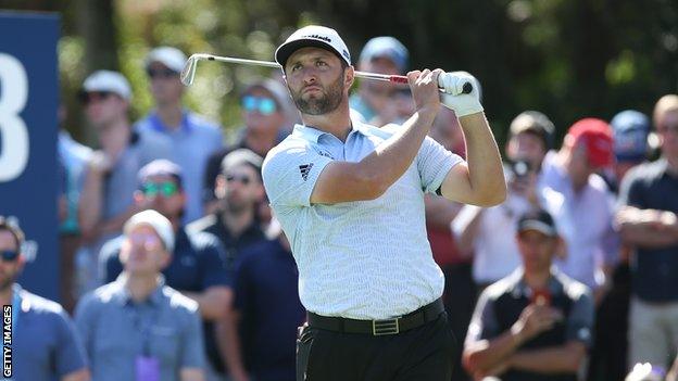 John Rahm hitting a shot at the Players Championship