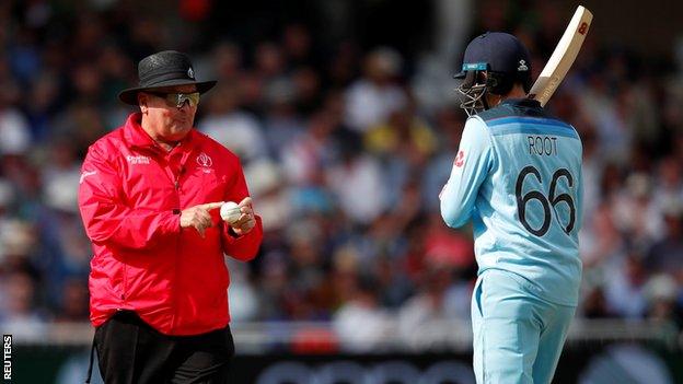 Umpire Marais Erasmus with England's Joe Root