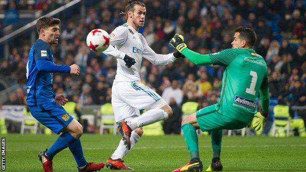 Gareth Bale of Real Madrid takes on a Fuenlabrada defender and goalkeeper in the Copa del Rey