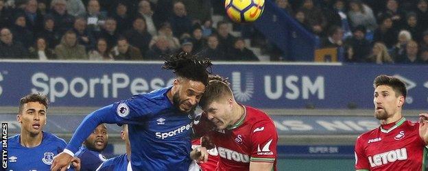 Ashley Williams heads the ball clear for Everton against his former club Swansea City