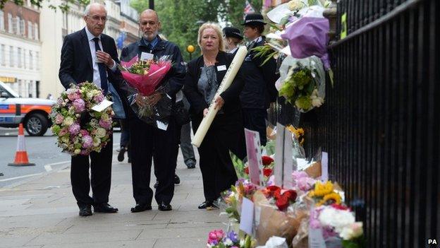 People laying flowers in Tavistock Square