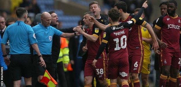Oxford United's manager Karl Robinson protects referee Andy Davies as controversy breaks out over the winning goal against Bradford