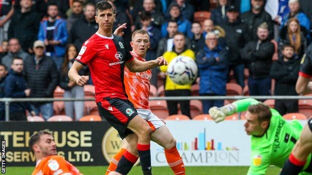 Shayne Lavery (centre) puts Blackpool ahead against Blackburn