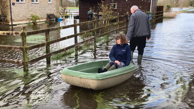 Mr and Mrs Smart using the boat outside thier home