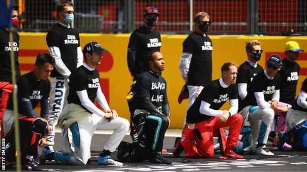 Charles Leclerc (far left) was one of seven drivers to remaining standing during the British Grand Prix as other drivers 'took a knee'