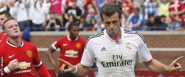 Gareth Bale celebrates scoring for Real Madrid against Manchester United as Wayne Rooney looks on