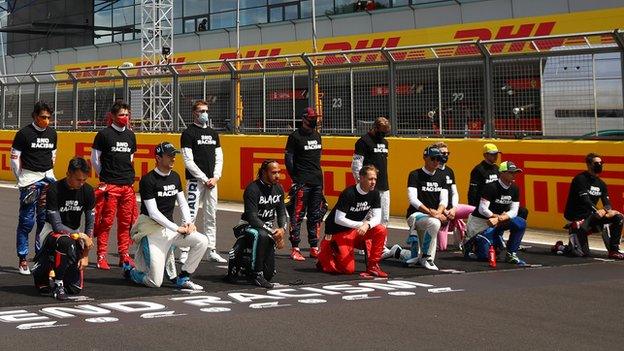 Drivers take the knee or stand during the anti-racism protest