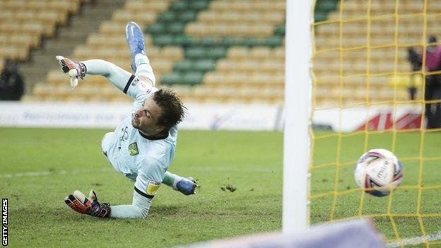 Norwich keeper Tim Krul tries to stop Lloyd Kelly's shot