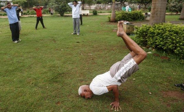 Indian men practice Yoga at a Jogger's park in Mumbai, India, 16 June 2015.