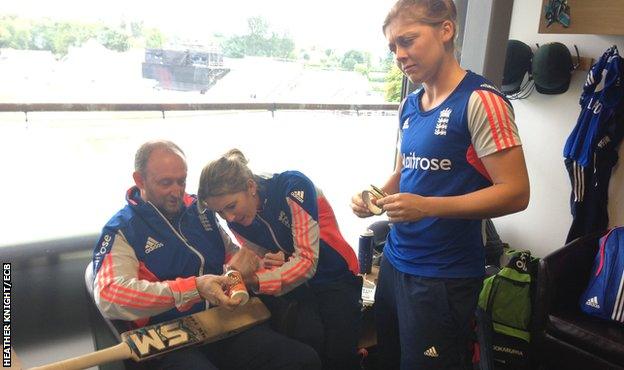 Heather Knight watches captain Charlotte Edwards repair her bat