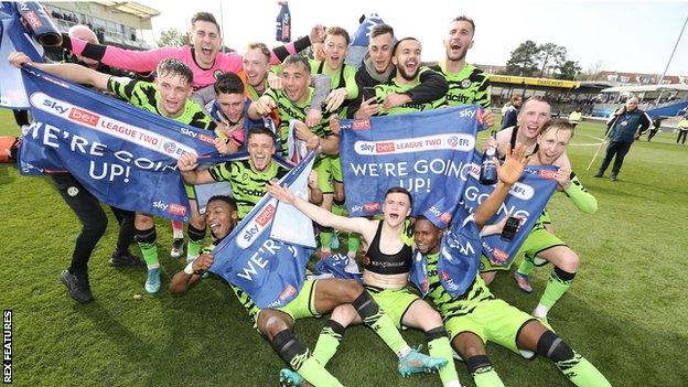 Forest Green Rovers players celebrate promotion on the pitch