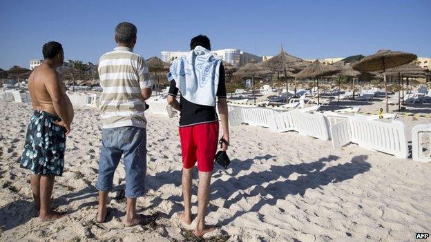 Tunisians stand on the beach of the Riu Imperial Marhaba Hotel in Port el Kantaoui, on the outskirts of Sousse south of the capital Tunis