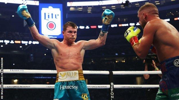 Alvarez raises his hands in front of Saunders seconds after landing the decisive uppercut