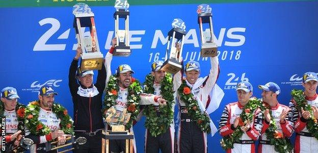 Toyota TS050 Hybrid LMP1's drivers Fernando Alonso of Spain (L), Kazuki Nakajima of Japan (R) and Sebastien Buemi of Switzerland (C), celebrate on the podium after winning