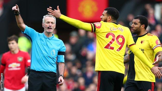 Troy Deeney and Etienne Capoue speak to referee Martin Atkinson