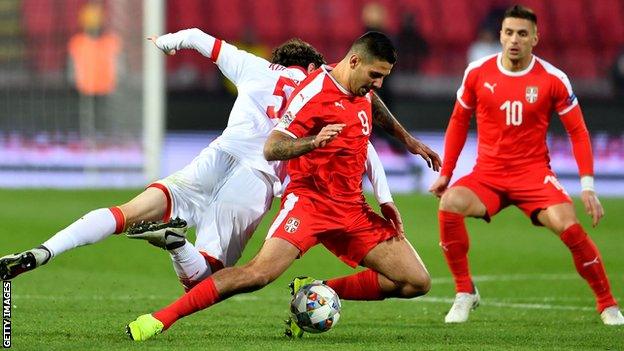 Serbia's Aleksandar Mitrovic (centre) vies with Montenegro's Boris Kopitovic