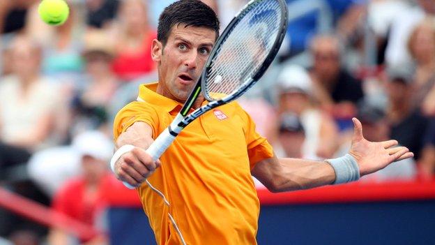 Novak Djokovic plays a volley