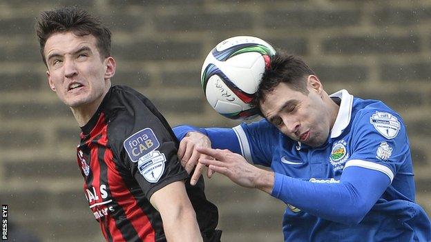 Josh Robinson battles with Linfield's Sean Ward during the Premiership game in April