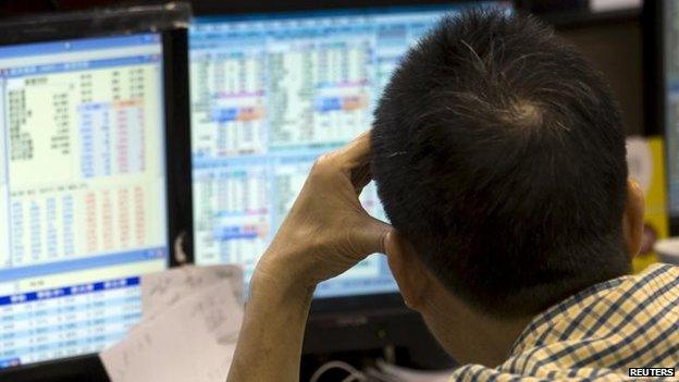 Investor monitoring share prices inside a brokerage firm during morning trading in Hong Kong