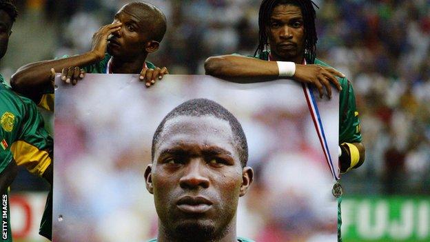 Samuel Eto'o (left) and Rigobert Song (right) hold up a photo of the late Marc Vivien Foe