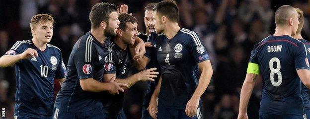 Scotland players mob James McArthur after the midfielder made it 2-2 in the first half