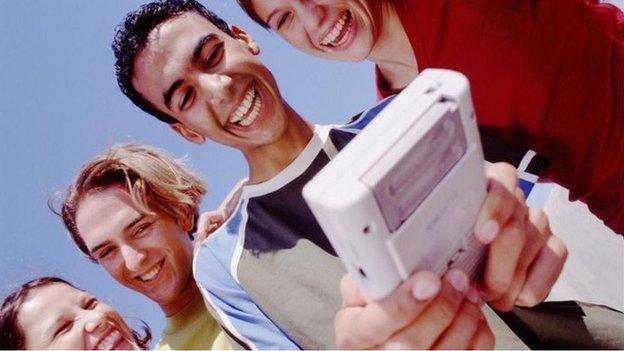 Teens playing on a Gameboy