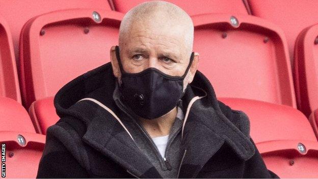 Warren Gatland wears a mask as he watches some Lions contenders