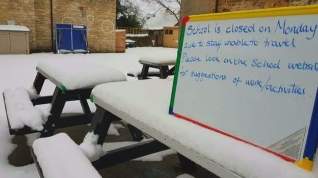 sign on snowy bench in school yard