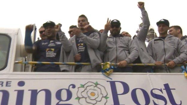 Leeds Rhinos players on an open-top bus celebrate their win