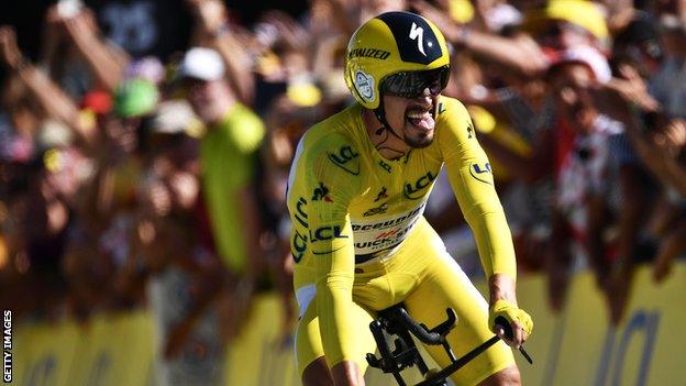 Julian Alaphilippe sticks out his tongue as he crosses the line after winning the stage 13 time trial