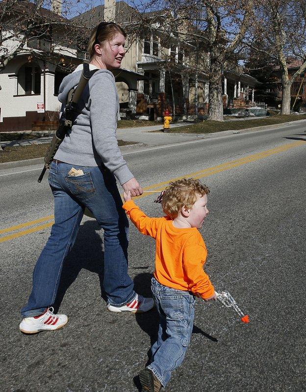 Kiri Davidson, left and her son Keaton, walk up State Street with her AR-15 she got for Valentines Day to a gun rights rally at the Utah State Capitol on March 2, 2013 in Salt Lake City, Utah