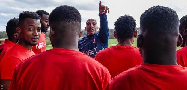 Middlesbrough coach Curtis Fleming shows refugee footballers around the club's training base