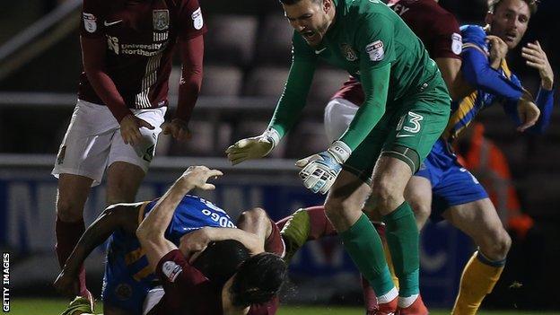 Abu Ogogo (on top) and John-Jo O'Toole grappled on the floor following their 65th-minute confrontation at Sixfields