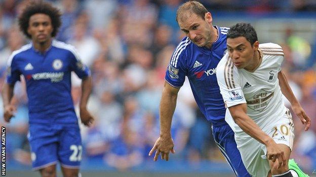 Swansea City winger Jefferson Montero beats Chelsea full-back Branislav Ivanovic